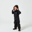 Pojke som står med sidan mot kameran med Tretorn Kids Packable rainset på sig i färgen jet black