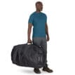 en man bär Osprey Transporter Duffel 150L (unisex)