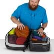 en person packar en Osprey Transporter Squffel 44L resväska (unisex)