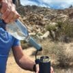 Man som använder Lifestraw Peak Series Solo Personal Water Filter Straw vattenfilter